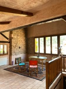 Pokój z 2 krzesłami, stołem i oknami w obiekcie La Casa del Bosque w mieście Cabra de Mora