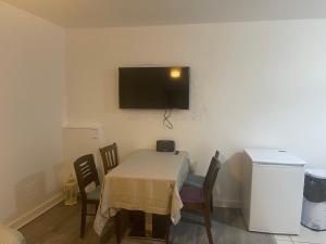 um quarto com uma mesa com cadeiras e uma televisão na parede em 2 Bed Flat Right in Centre of Portrush town em Portrush
