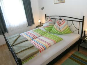 Una cama con mantas y almohadas coloridas. en Modern holiday apartment in Rennweg am Katschberg, en Rennweg