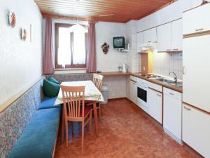 a small kitchen with a table and chairs and a couch at Holiday Home in Salzburg near Ski Area with Balcony in Fusch an der Glocknerstraße