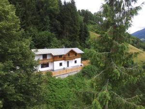 a house on the side of a hill with trees at Chalet in Bruck Grossglocknerstrasse near ski lift in Bruck an der Großglocknerstraße