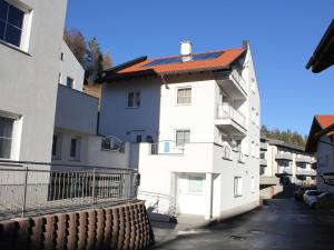 a white apartment building with a red roof at Chalet in Fiss near Ski Lifts in Fiss