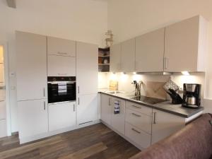 a kitchen with white cabinets and a counter top at Modern apartment with Wilder Kaiser view in Kirchdorf in Tirol