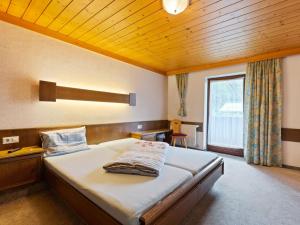 ザールバッハ・ヒンターグレムにあるApartment in Saalbach Hinterglemm near Ski Areaの木製の天井のベッドルーム1室(大型ベッド1台付)