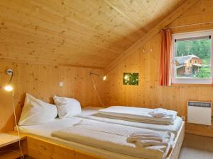 a bedroom with a bed in a wooden cabin at Chalet in Sankt Georgen near ski area in Sankt Georgen ob Murau