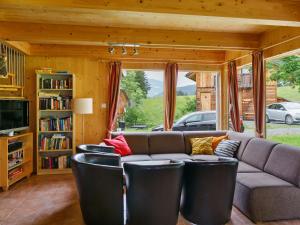 a living room with a couch and some chairs at Chalet in Sankt Georgen near ski area in Sankt Georgen ob Murau
