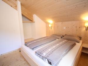 Posto letto in una piccola camera con soffitti in legno. di Wooden chalet in Hohentauern with sauna a Hohentauern