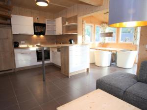 una grande cucina con armadi bianchi e tavolo di Wooden chalet in Hohentauern with sauna a Hohentauern