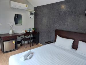 - une chambre avec un lit et un bureau avec un ordinateur dans l'établissement The Sept Korat, à Nakhon Ratchasima
