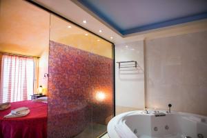 y baño con bañera y ducha de color rojo. en Anastazia Luxury Suites & Spa, en Atenas