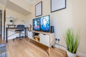 sala de estar con TV y escritorio en Pierocks Wickets Luxury Entire house, Free Parking and WI-FI in Maidenhead, en Maidenhead