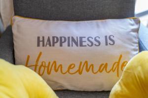 a pillow with the words happiness is homogeneous at Pierocks Wickets Luxury Entire house, Free Parking and WI-FI in Maidenhead in Maidenhead