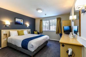 ein Hotelzimmer mit einem großen Bett und einem Schreibtisch in der Unterkunft Days Inn Hotel Fleet in Fleet