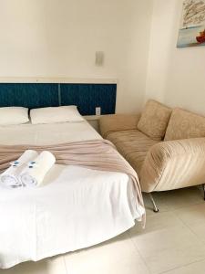 2 camas y un sofá en una habitación en Pousada Marina da Praia, en Garopaba