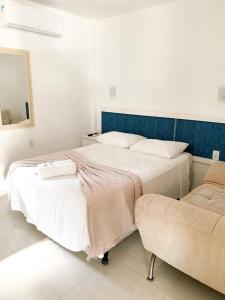 1 dormitorio con 2 camas y sofá en Pousada Marina da Praia, en Garopaba