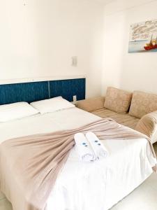 1 dormitorio con 1 cama con 2 zapatillas en Pousada Marina da Praia, en Garopaba