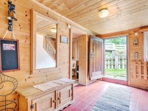 Cette cabane en rondins dispose d'une grande fenêtre et d'un escalier. dans l'établissement Welcoming Holiday Home with Garden in Tyrol, à Matrei in Osttirol