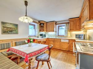 une cuisine avec une table et un vase de fleurs. dans l'établissement Welcoming Holiday Home with Garden in Tyrol, à Matrei in Osttirol