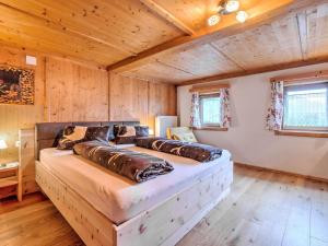 a large bed in a room with wooden walls at Welcoming Holiday Home with Garden in Tyrol in Matrei in Osttirol
