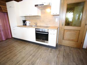 a kitchen with a sink and a stove top oven at Spacious Apartment in Sankt Johann im Pongau with Garden in Wagrain