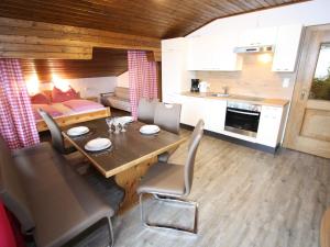 a kitchen and a dining room with a table and chairs at Spacious Apartment in Sankt Johann im Pongau with Garden in Wagrain