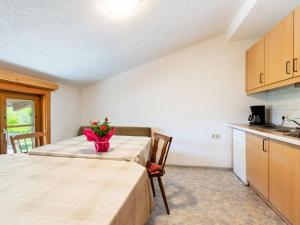 eine Küche und einen Tisch mit einer Blumenvase darauf in der Unterkunft Warm Apartment in Uttendorf Salzburg near Ski Area in Uttendorf
