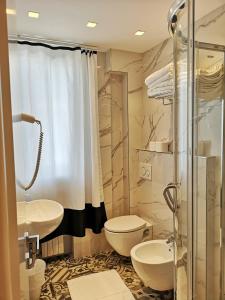 y baño con lavabo, aseo y ducha. en Family Suite Appartments Orchidea Blu, en Rímini