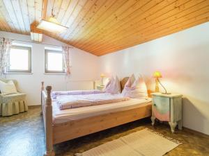ein Schlafzimmer mit einem Bett und einer Holzdecke in der Unterkunft Sunlit Apartment near Ski Area in Tyrol in Kirchdorf in Tirol