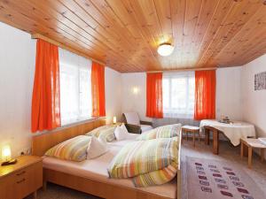 バルトロメベルクにあるDetached country house in Goldegg with sauna close to the ski areaのベッドルーム1室(オレンジ色のカーテン、ベッド1台、テーブル付)