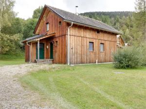 a wooden building with a green door in a field at Chalet in Stadl an der Mur near the ski area in Stadl an der Mur
