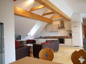 eine Küche im Dachgeschoss und ein Wohnzimmer mit Holzdecken in der Unterkunft Apartment in Sankt Margarethen near Ski Area in Sankt Margarethen im Lungau
