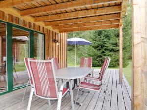 a table and chairs on a deck with an umbrella at Chalet in Stadl an der Mur near the ski area in Stadl an der Mur