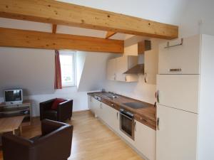 a kitchen with a refrigerator and a table with chairs at Modern Apartment in Sankt Margarethen near Ski Area in Sankt Margarethen im Lungau