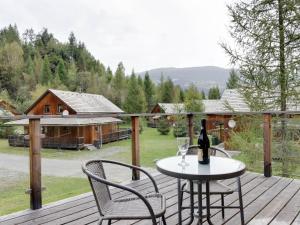 a deck with two chairs and a table with a bottle of wine at Chalet in Stadl an der Mur near the ski area in Stadl an der Mur