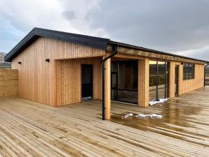 a wooden building on a wooden deck at Dalamynni in Hólmavík