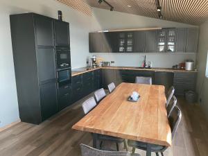 a large kitchen with a wooden table and chairs at Dalamynni in Hólmavík