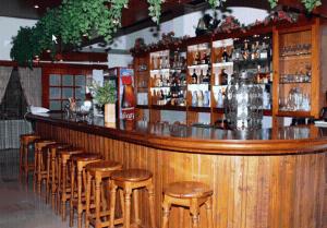a bar with a row of wooden stools at Hotel Themisto in Nikolaíika