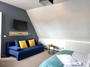 a bedroom with a blue couch and a flat screen tv at Lumiere House Sibiu in Sibiu
