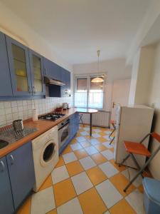 cocina con armarios azules y suelo de color naranja y blanco en M Apartments - Info Park, en Budapest