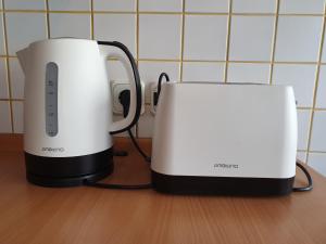 two white toasters sitting next to each other on a counter at M Apartments - Info Park in Budapest