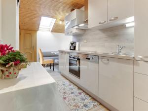 cocina con armarios blancos y encimera blanca en Apartment in Eberndorf Carinthia with sauna, en Eberndorf