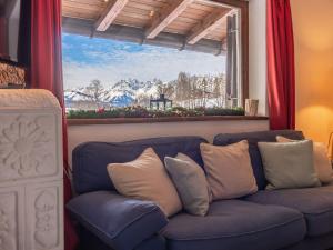 キッツビュールにあるCosy Apartment in Kutzbuhel with barbecueの窓付きの客室で、青いソファが備わります。