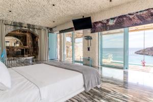 una camera da letto con un letto e vista sull'oceano di Calilo a Manganari