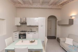 una cucina e un soggiorno con tavolo e divano di Brigata House - Luxury 2 beds, wifi, balcony,sea view - Key to Villas a Castelsardo