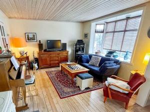 a living room with a couch and a tv at 8 person holiday home in MÅLØY-By Traum in Måløy