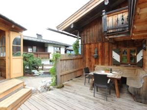 a wooden deck with a table and chairs on it at Attractive chalet right on the piste with sauna in Sankt Johann in Tirol