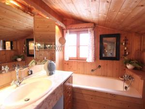 a bathroom with a tub and a sink and a tub and a bath tub at Attractive chalet right on the piste with sauna in Sankt Johann in Tirol