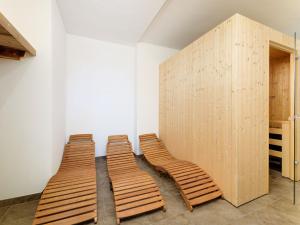três cadeiras de madeira sentadas ao lado de uma parede em Apartment in St Johann im Pongau with sauna em Alpendorf