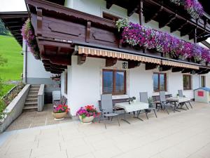 um pátio com mesas, cadeiras e flores num edifício em Beautiful apartment in Brixen in the Thale em Brixen im Thale