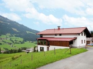 uma casa branca com um telhado vermelho numa colina em Beautiful apartment in Brixen in the Thale em Brixen im Thale